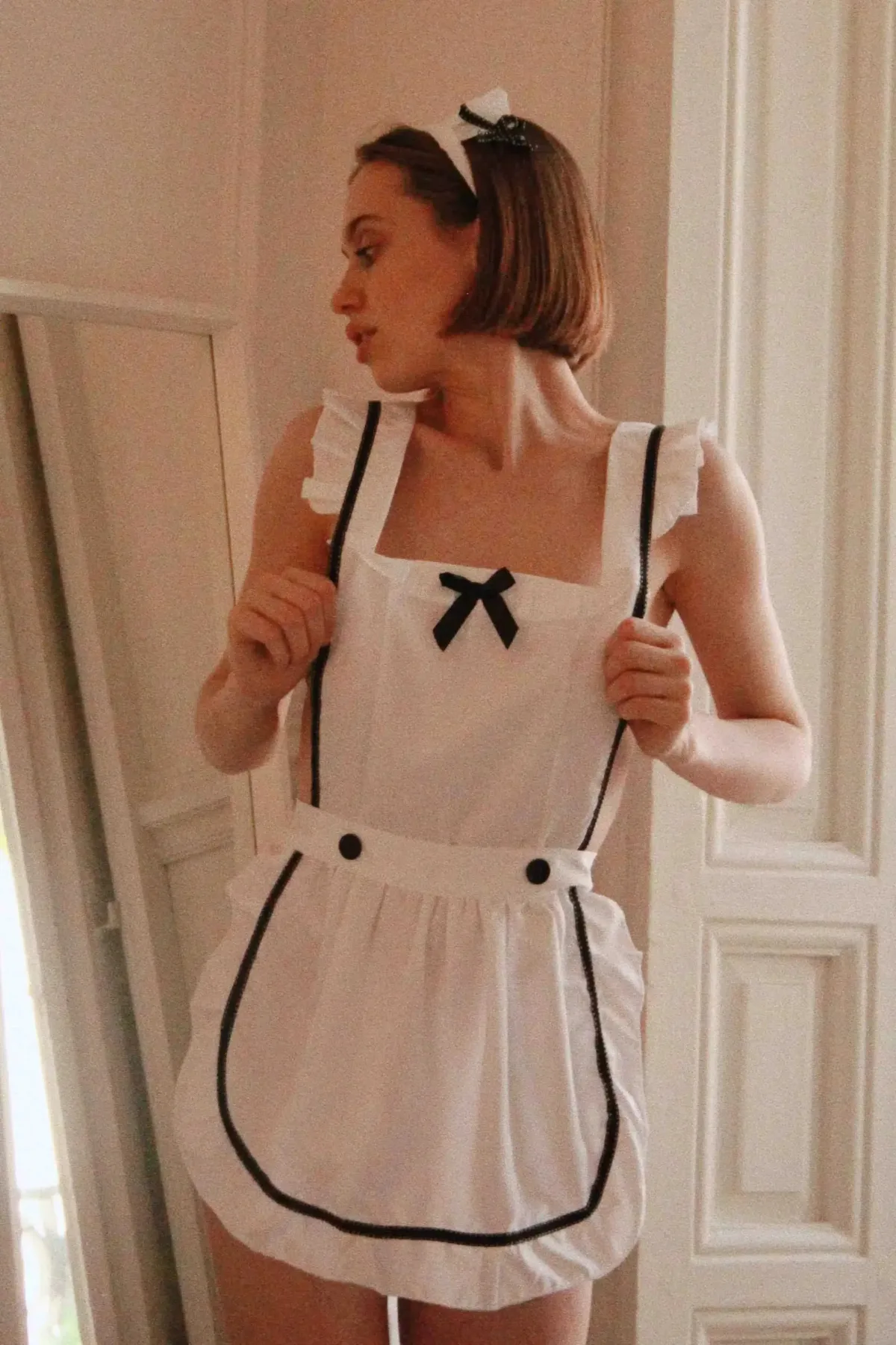 Рюші на плечах і чорний бантик костюма покоївки Pinafore, вигляд спереду